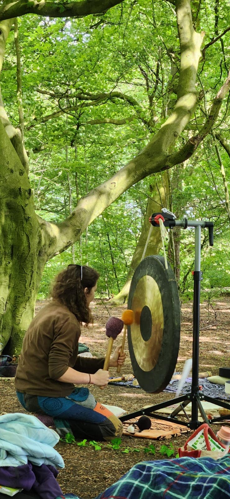 Charlotte playing gong in forest